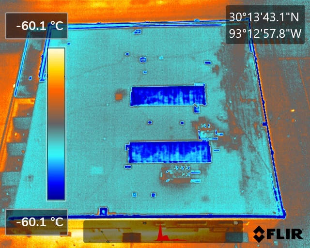 an aerial view of a building with a blue roof - Roof Testing For Hail Damage