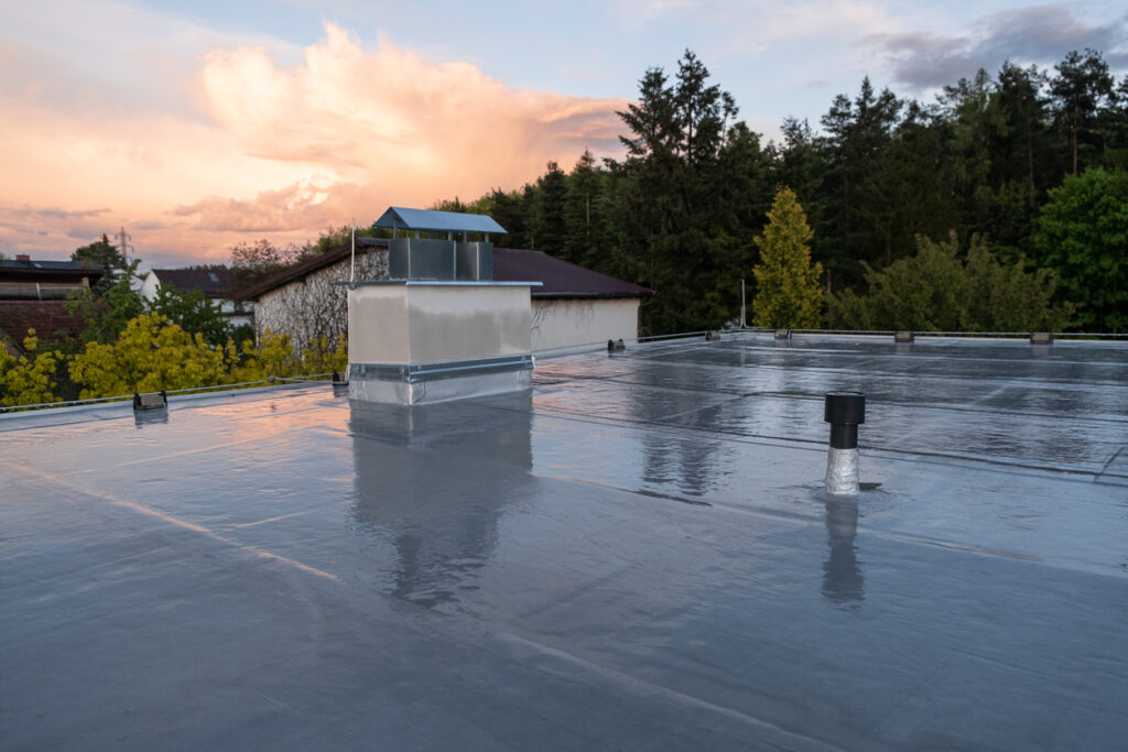 a roof with a chimney and trees in the background - Microscopic Evaluation Roof Testing