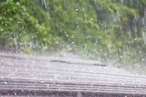 a person walking in the rain with an umbrella - Post-Storm Inspections